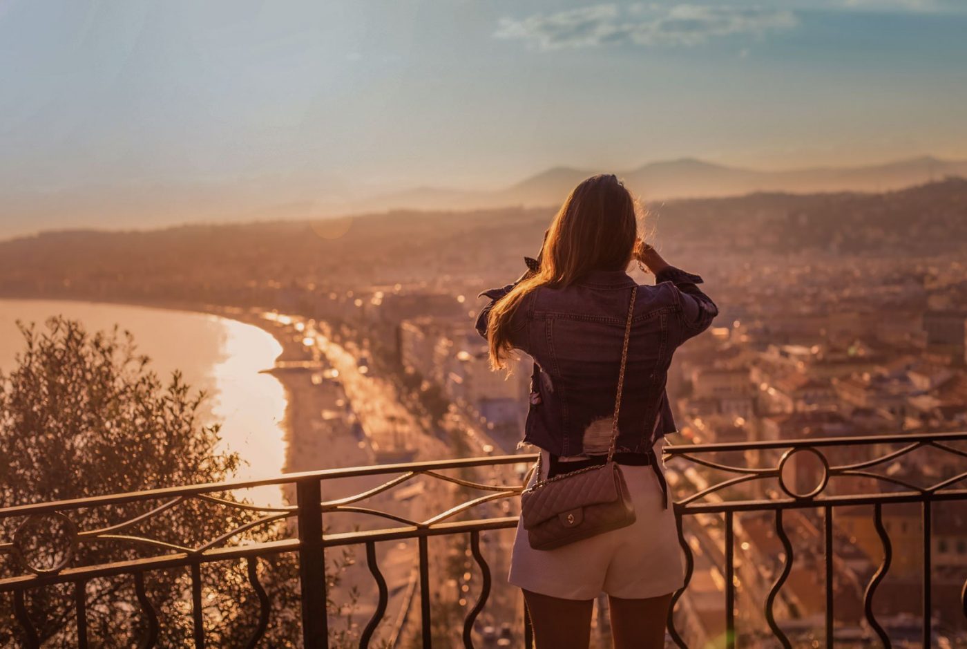 A girl looking over Nice beach at sunset, the best hostels in France. Book with Villa Hostels.