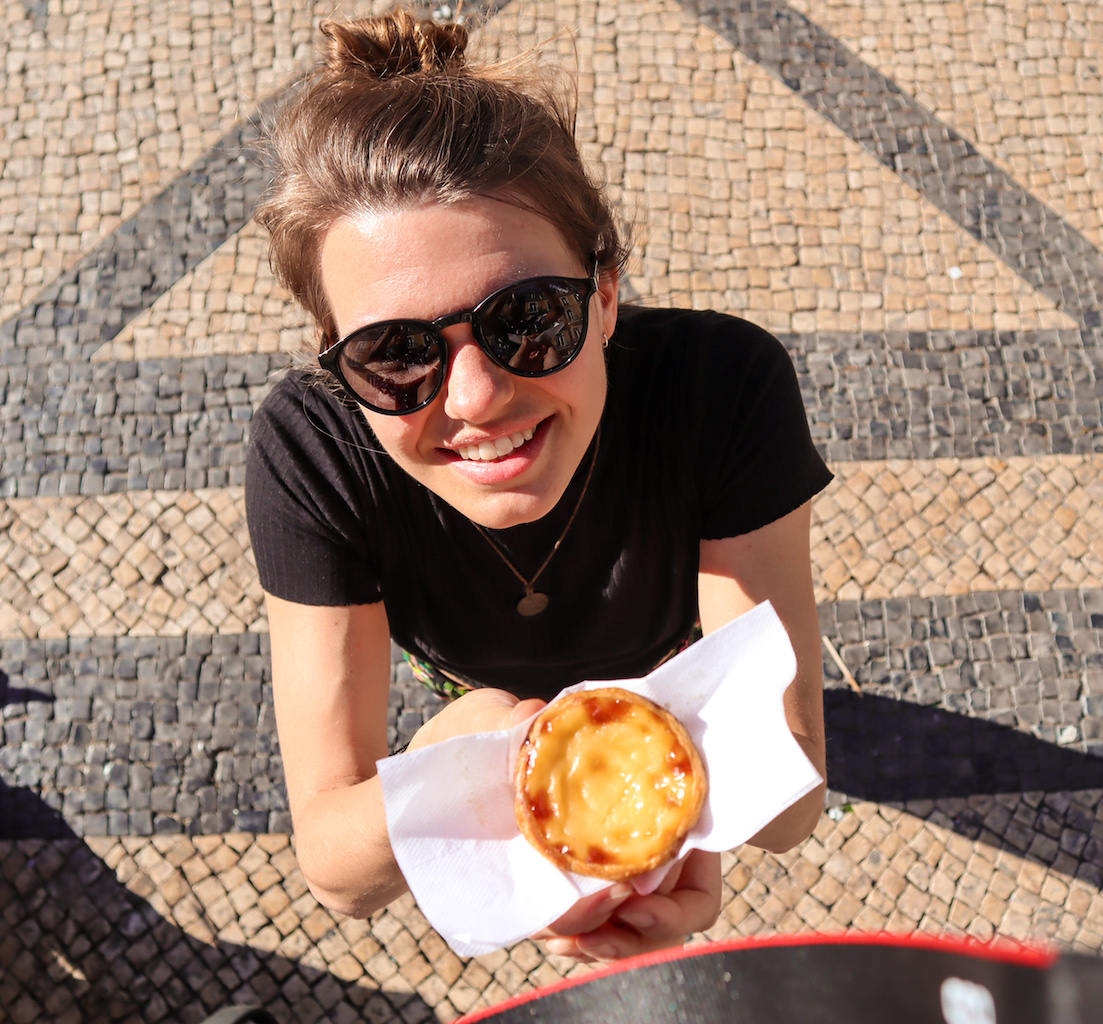 A girl smiling with a Pastel de Nata in Lisbon, Portugal